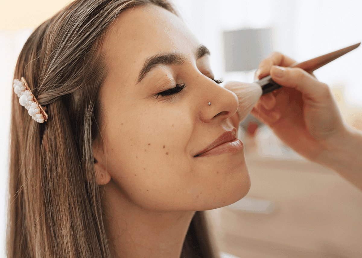 Girl Applying Brush Makeup to Face