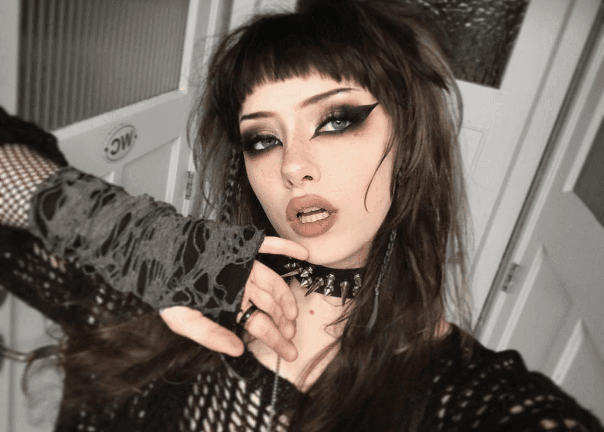 A woman with a goth makeup look, wearing cute goth makeup and matching her skin tone