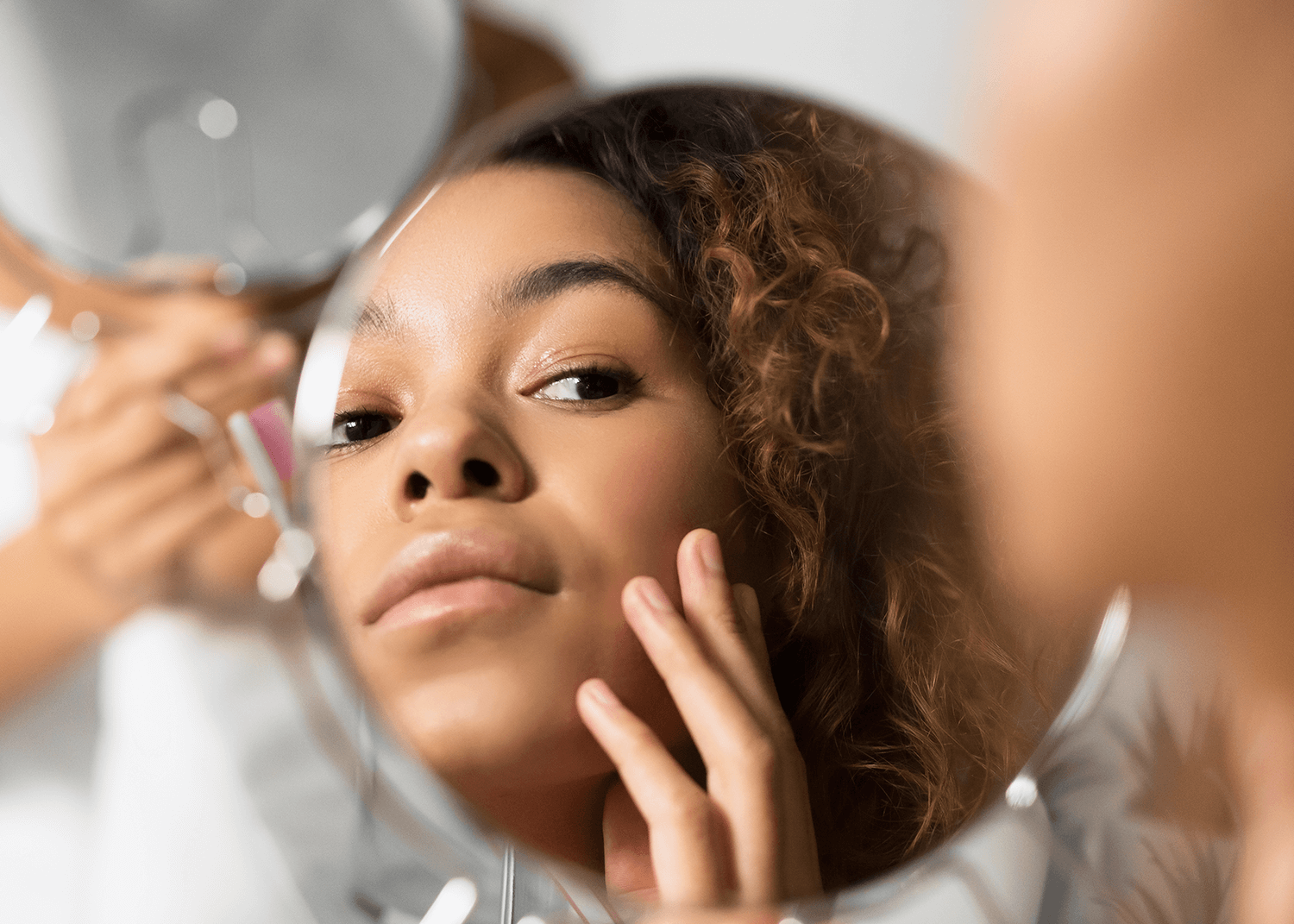 African American Woman Applying Skin Product