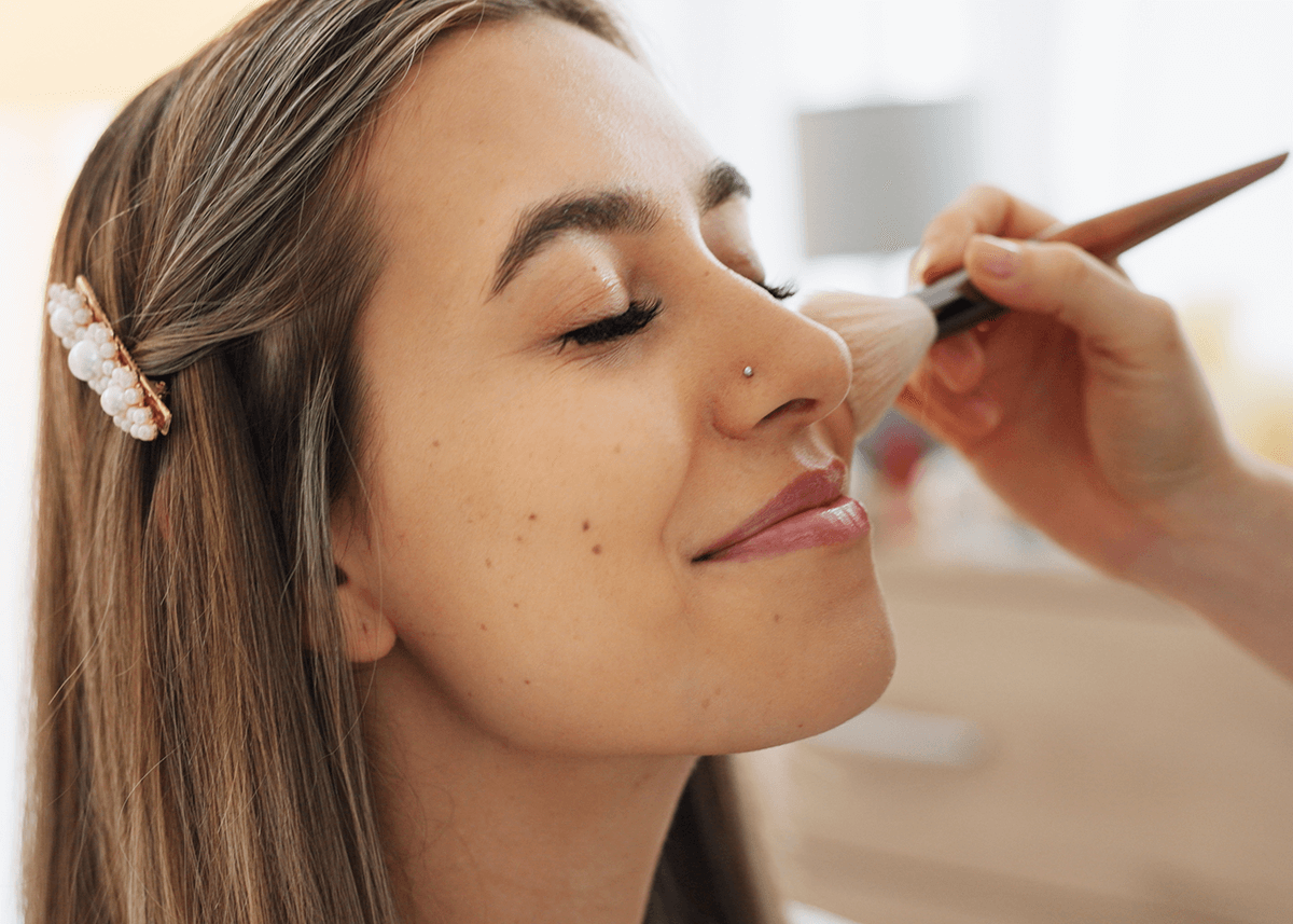 Girl Applying Brush Makeup to Face