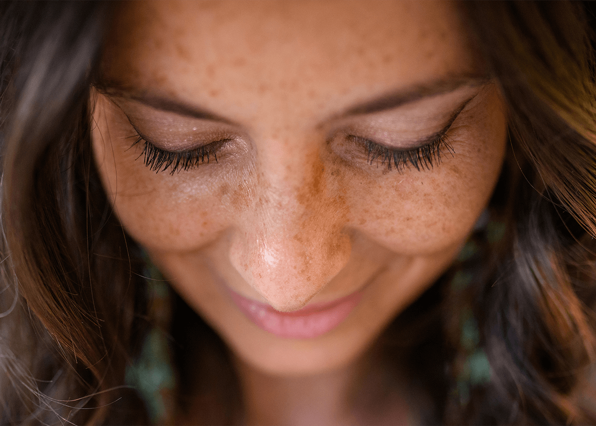 Girl with freckles looking down
