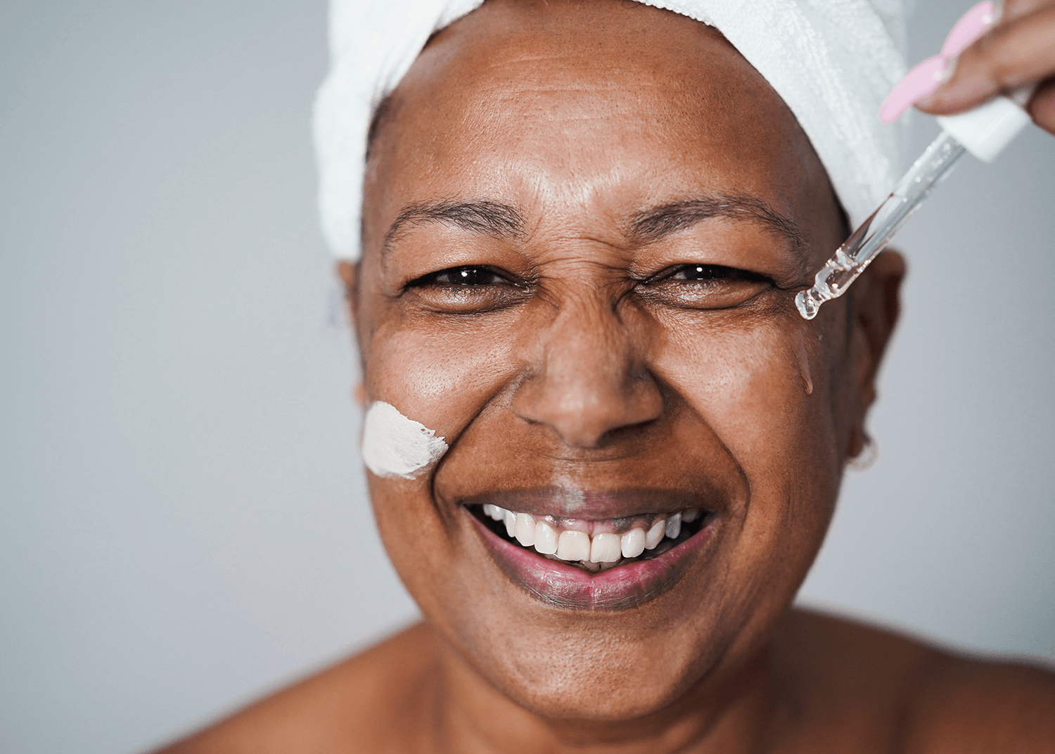 Mature African Woman Applying Serum to Skin