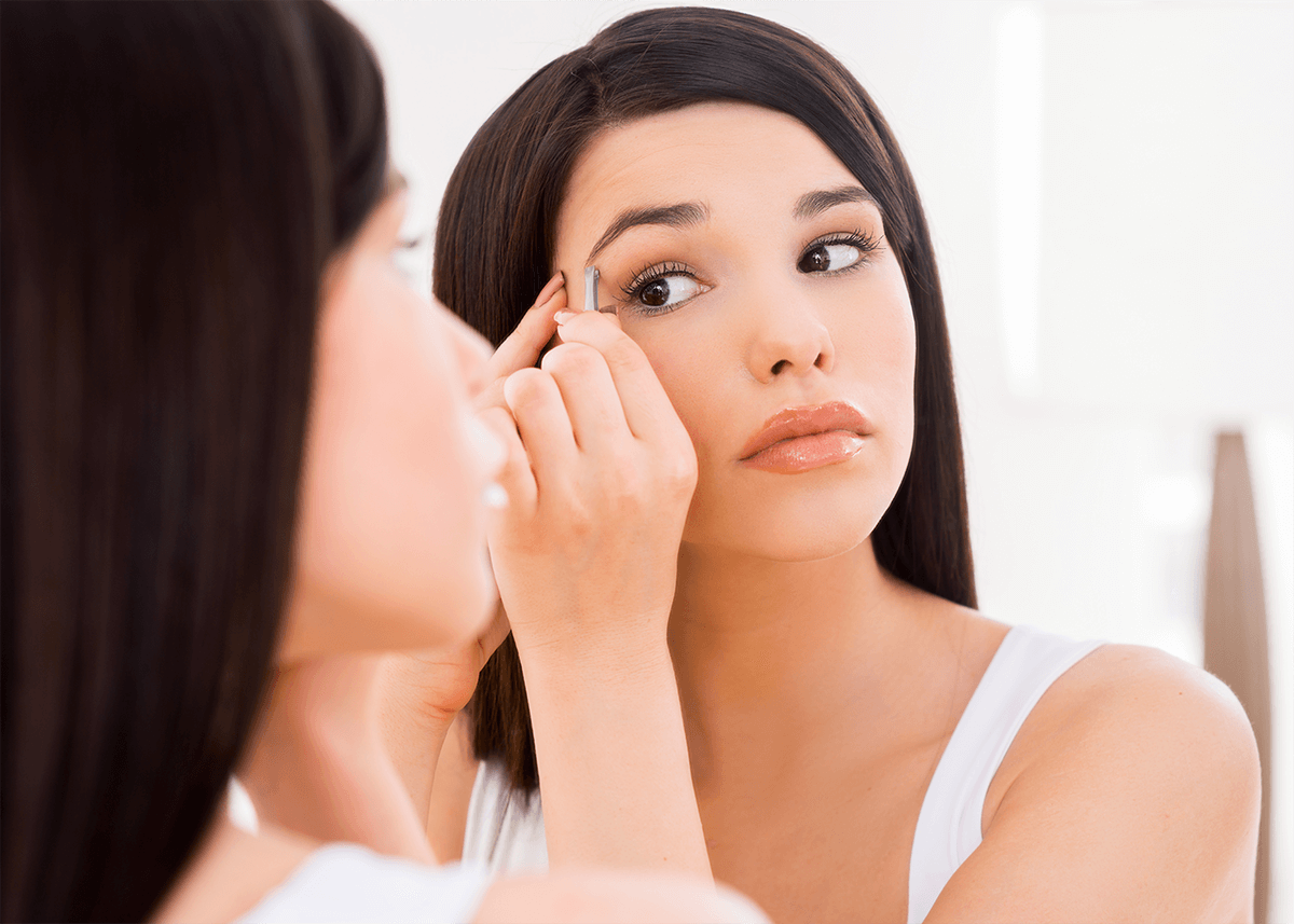 Woman in Mirror Plucking Eyebrows