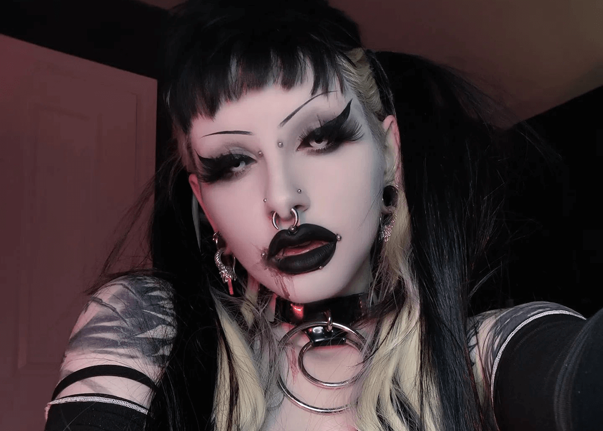 A woman wearing dark lipstick and goth glam makeup
