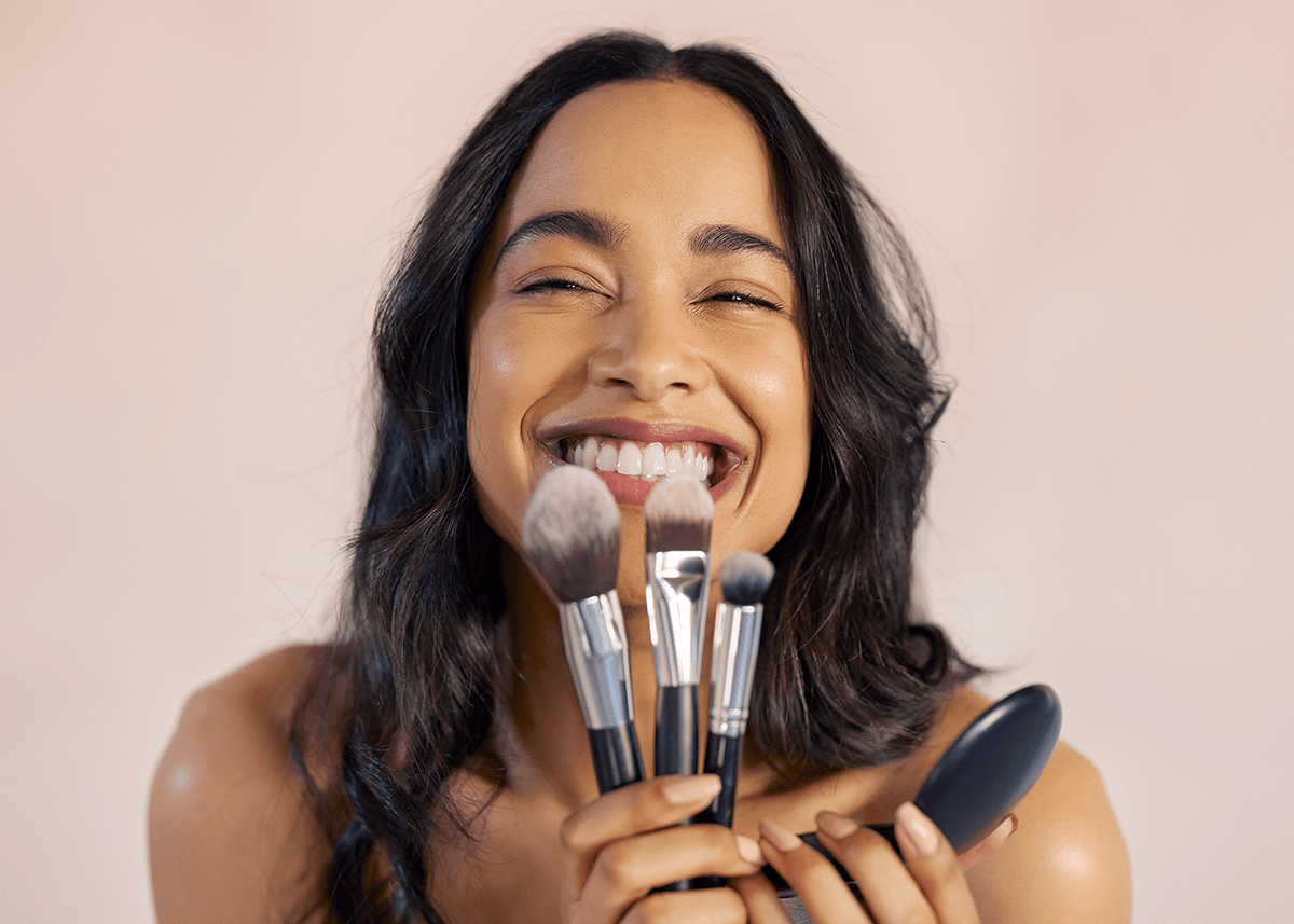 Girl holding makeup foundation brushes