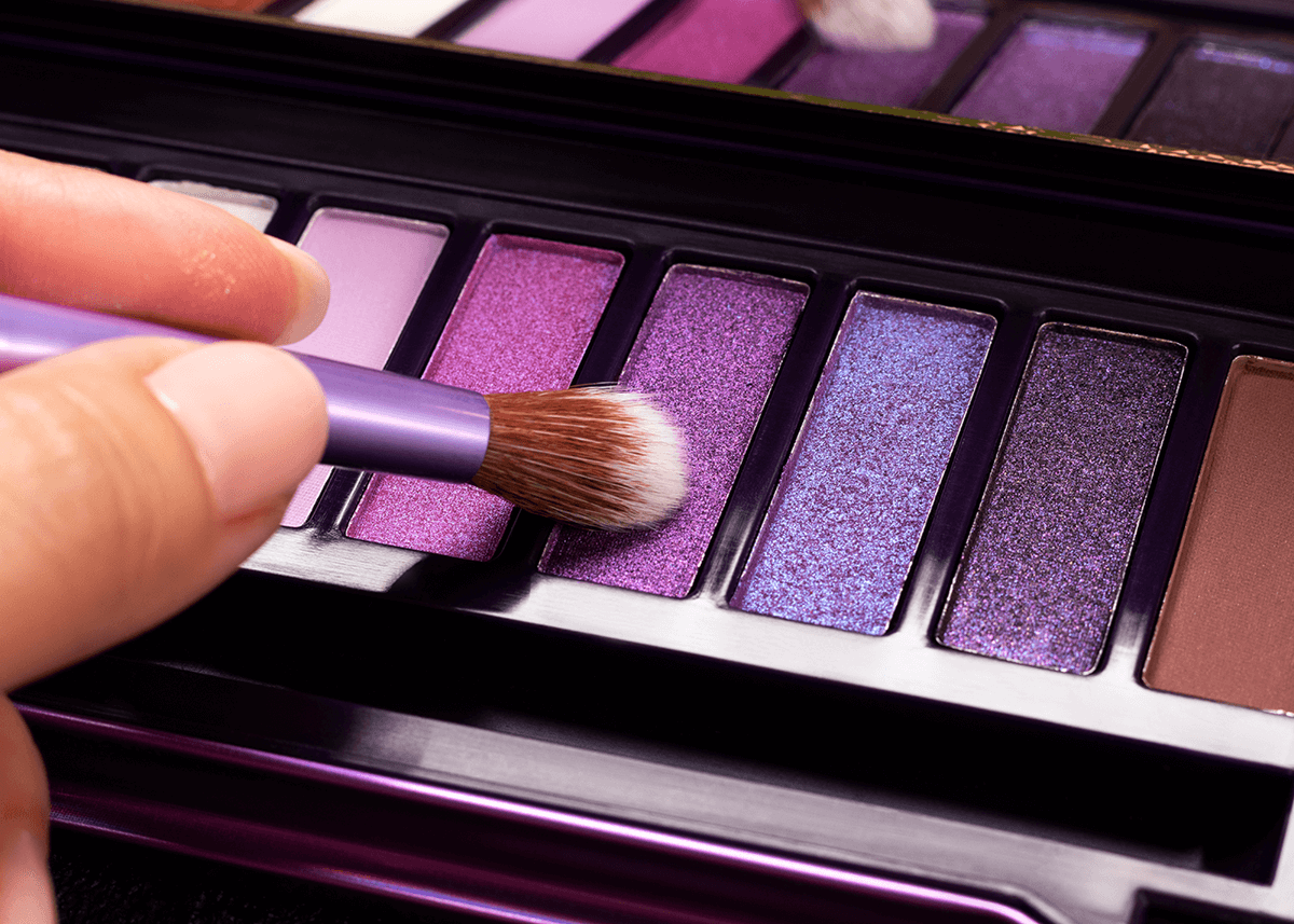 Purple Eyeshadow Pallet with Brush Applying Pigment