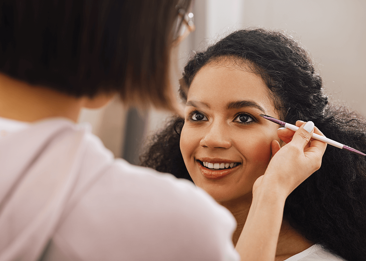 Makeup artist applying eyebrow makeup to woman