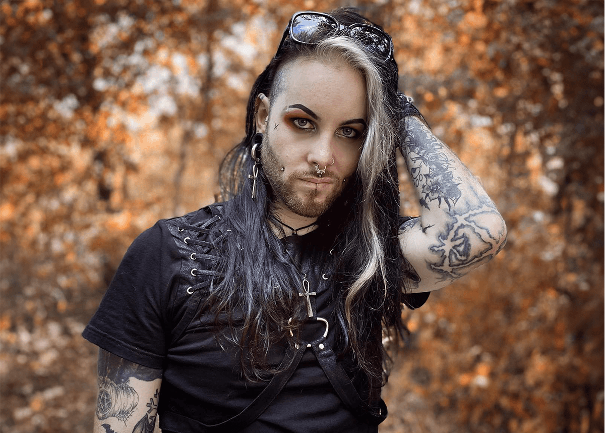A male model showcasing goth makeup with dark eyeliner