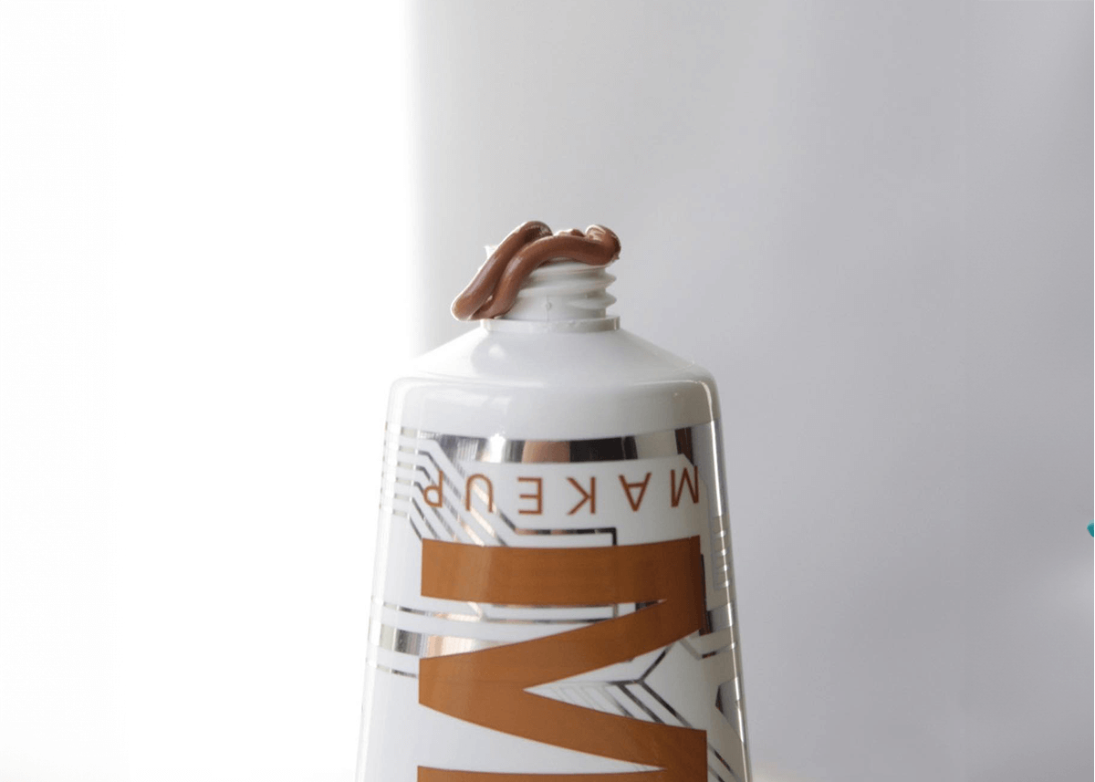 Liquid bronzer being squeezed from a tube